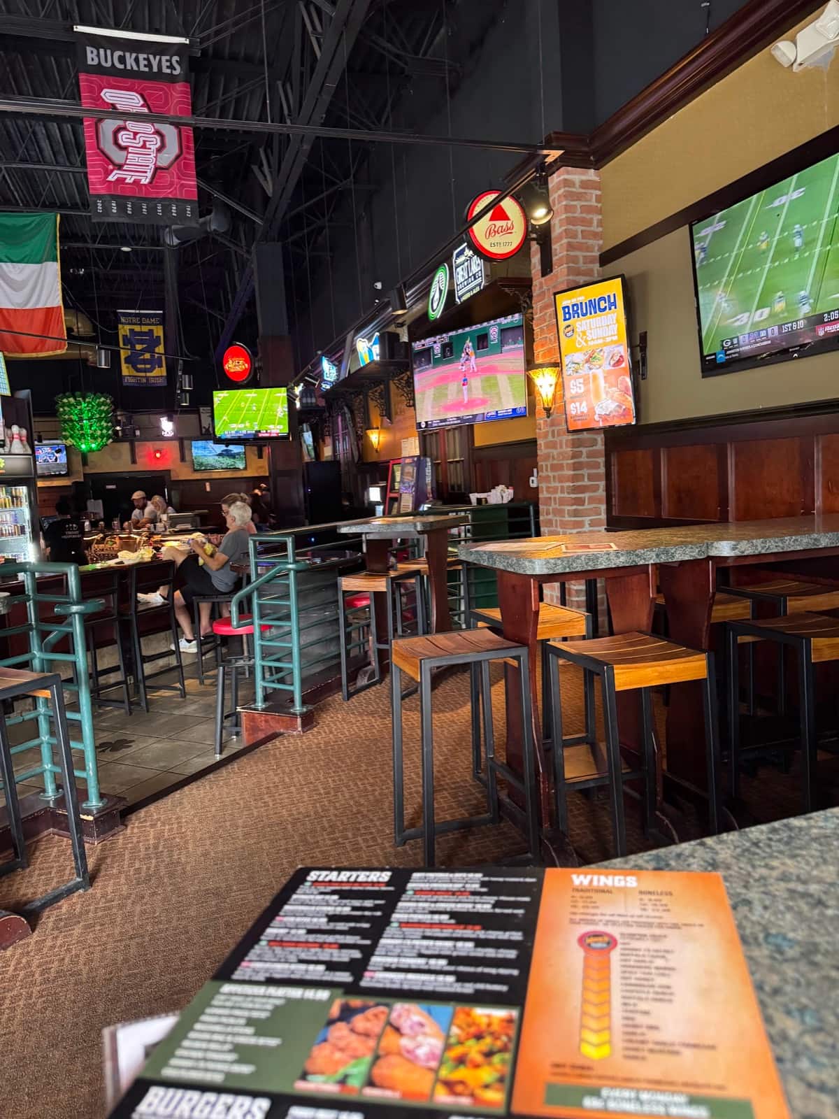 High-top tables and the TV wall inside Johnny J's Pub & Grille